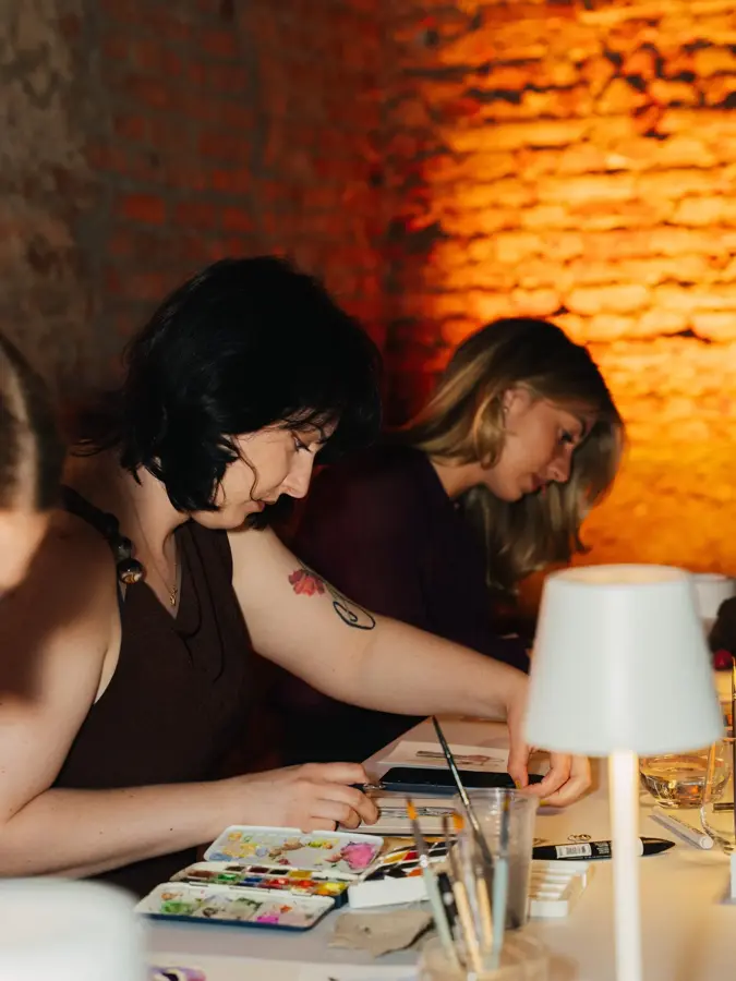 Dvije umjetnice crtaju za stolom